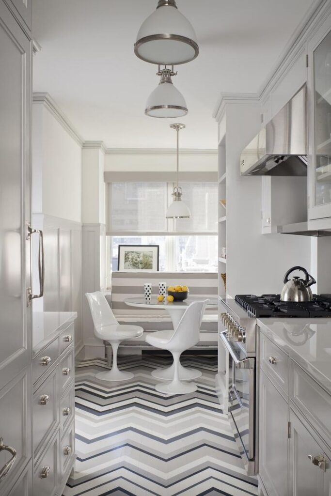 A kitchen with white cabinets and black and white floor