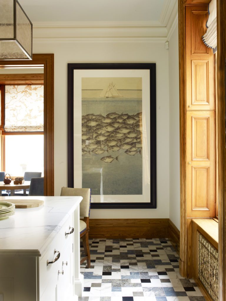 A large picture hangs in the corner of this kitchen.