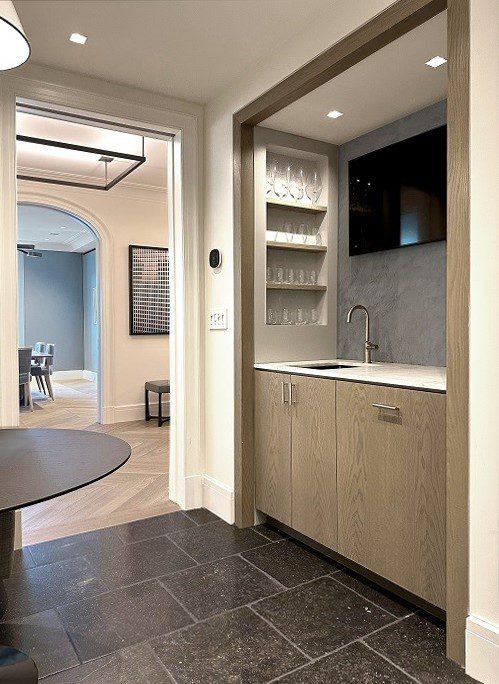 A kitchen with a sink, refrigerator, and tv.