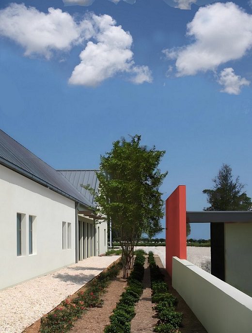 A white building with a red and white fence.