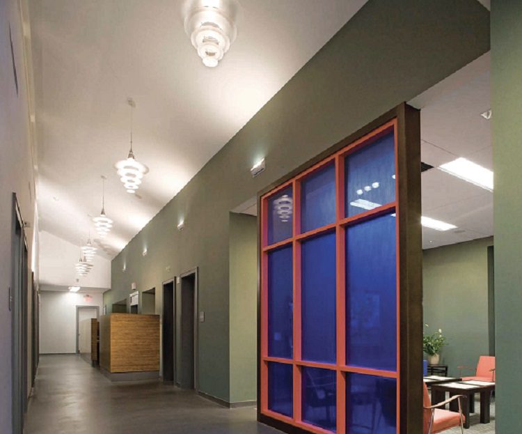 A hallway in an office with a glass door.