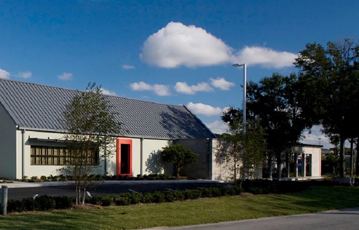 A building with a metal roof and a red door.