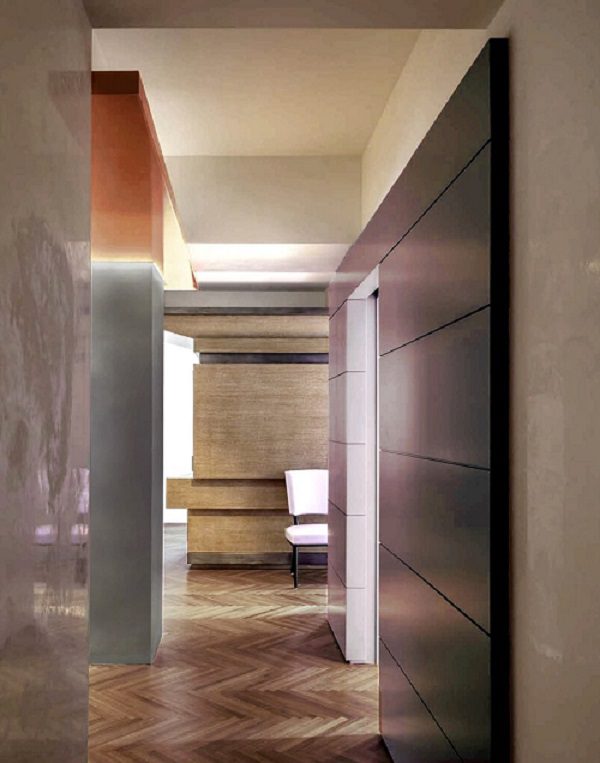 A hallway with a wooden floor and a wooden door.