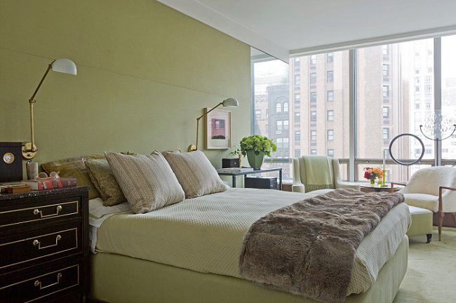 A bedroom with green walls and furniture.