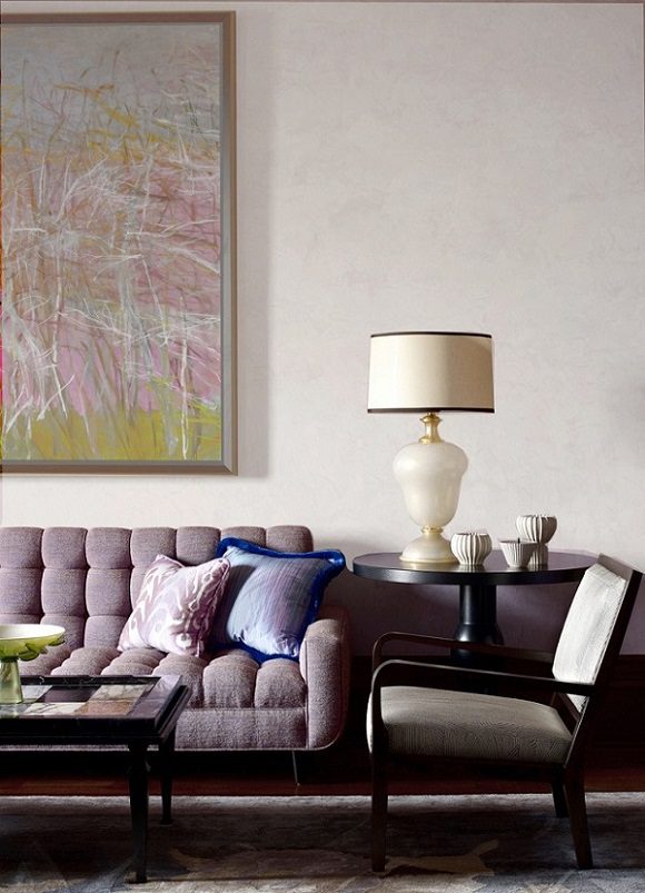 A living room with a large painting on the wall.