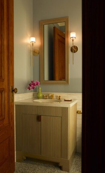 Bathroom renovation at The Dakota Apartments featuring fluted custom vanity and preserved historic woodwork