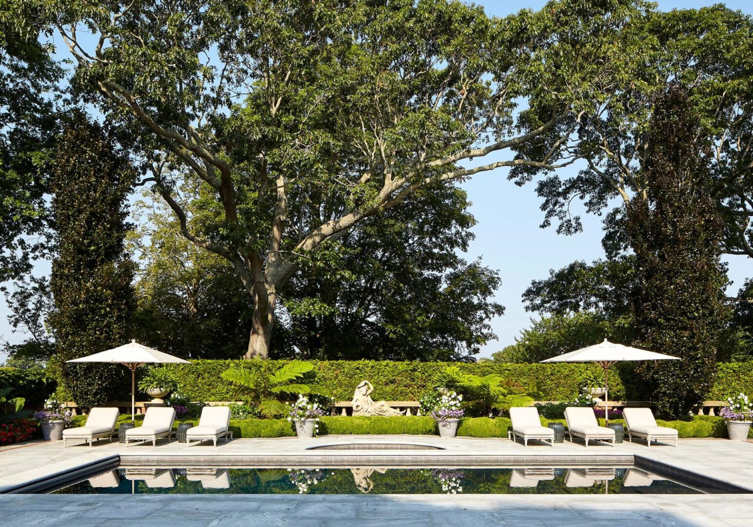 Pool with garden and sculpture at Southampton Estate