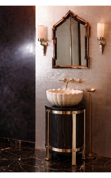Sculptural Manhattan powder room with silver leaf mosaic tile, carved stone basin, and custom pedestal vanity