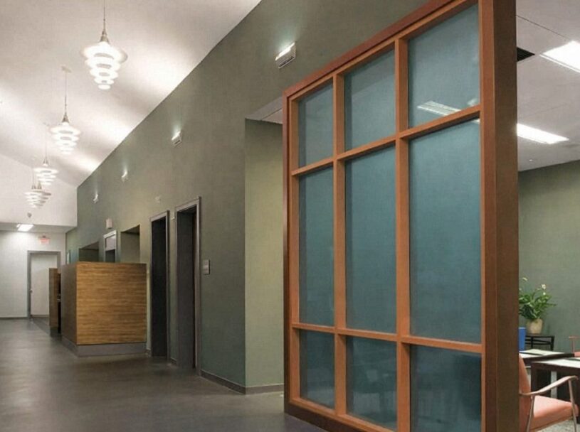 Contemporary Florida medical office interior with warm wood detailing, translucent partitions, and calming green tones